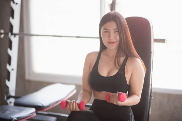 Deporte de las mujeres de ejercicio con mancuerna en el gimnasio — Foto de Stock