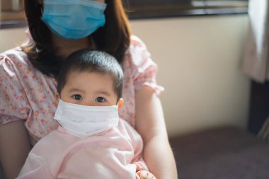Cerrahi maske takan bebek evde kalsın. Covid-19 koronavirüs konsepti