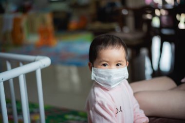 Cerrahi maske takan bebek evde kalsın. Covid-19 koronavirüs konsepti