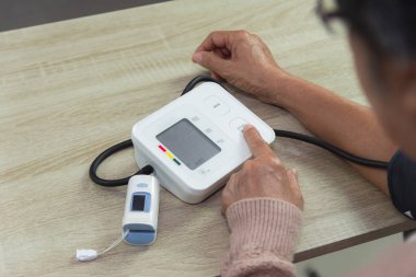 Tonometresi olan yaşlı kadın kan basıncını ölçüyor.