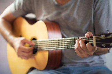 Akustik gitar çalan müzisyen.