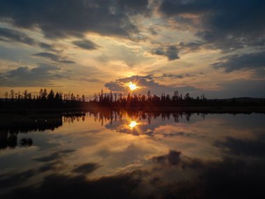 Gölün yüzeyindeki bulutlarda gün batımı