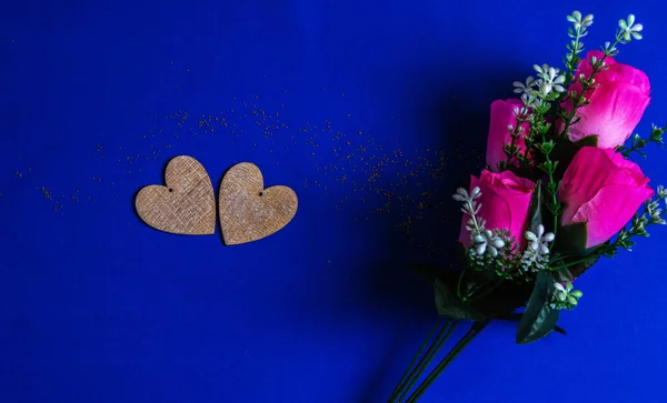 Two Wooden Hearts Lie Artificial Pink Flowers Blue Background — Stock Photo, Image