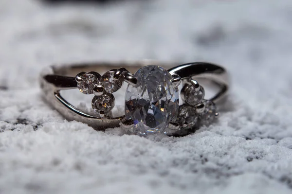 Silver ring for engagement to precious stones on blurred background