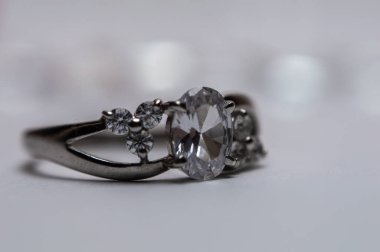 Bulanık arkaplanda taşlar olan gümüş bir halka.