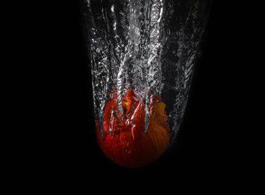 Sulu kırmızı elma suya düşüyor.