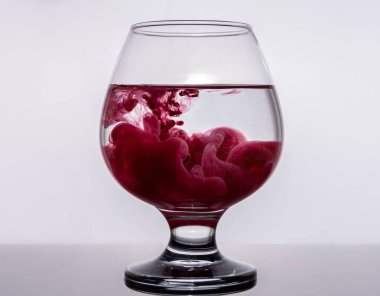 Renkli mürekkep bir bardak suya yayılır.