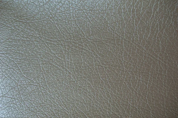 Beige faux leather texture. Artificial leather close-up