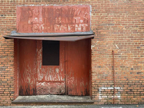 the old warehouse rusted alley roll up delivery door and brick wall entrance