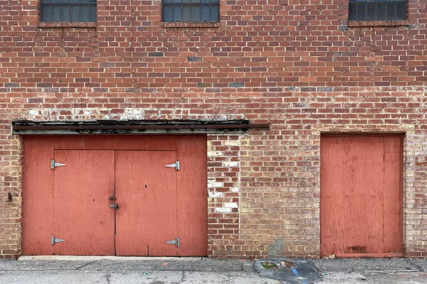 Uma Parede Tijolo Beco Armazém Abandonado Com Portas Vermelhas — Fotografia de Stock