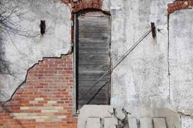 Soluk kırmızı tuğlalı bir duvarın kemerli penceresi.