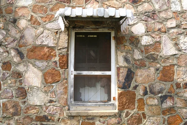 a vintage shutter screen window on a retro stone wall farm house