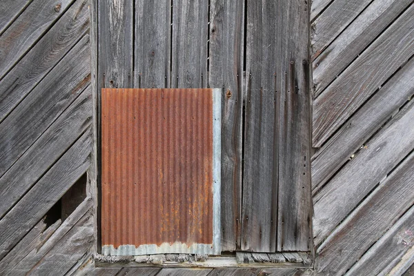 a retro old wood warehouse wall with rusted metal window