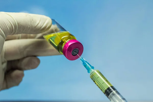 Hand holding syringe and medicine vial prepare for injection with surgical equipment and medicine vial background.
