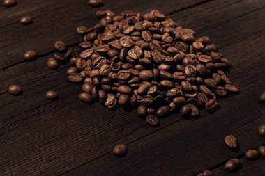 Eski ahşap arka planda kızarmış kahve çekirdekleri.