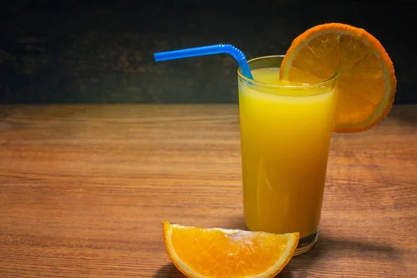 玻璃的鲜榨橙汁木制的桌子上 — 图库照片