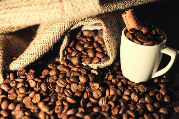 coffee cup of coffee beans with cinnamon on wooden background