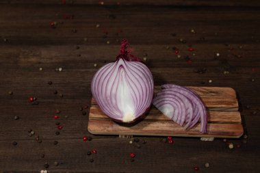 Kırmızı soğan ikiye bölünmüş, tahta bir arka planda. Yakın plan..