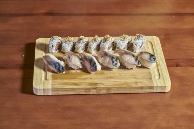 Bambu masasında çeşitli balık ve pirinç suşilerinin sunumu