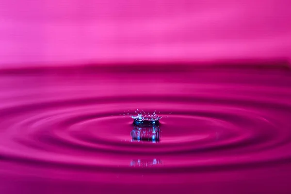 Капля Воды Брызги Макроса Рябью Розовом Фоне — стоковое фото
