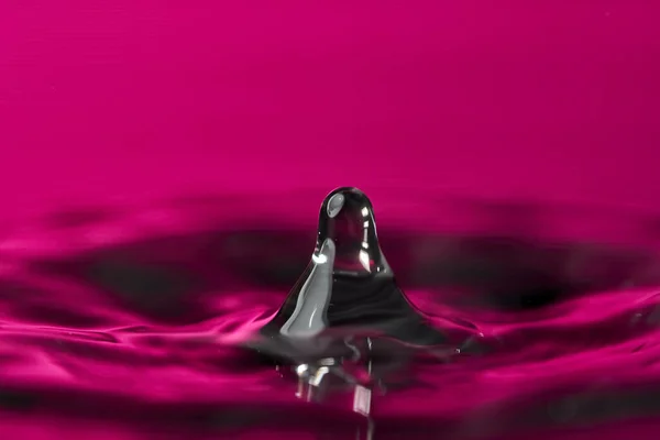 Капля Воды Брызги Макроса Рябью Розовом Фоне — стоковое фото