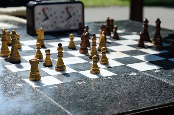 Каменная шахматная доска с деревянными шахматами — стоковое фото