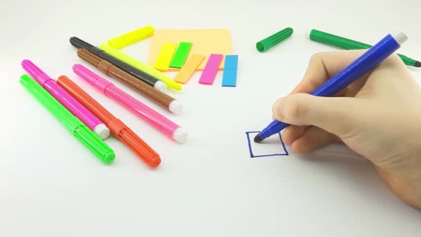 子供が白いシートの上に家と太陽を描き — ストック動画