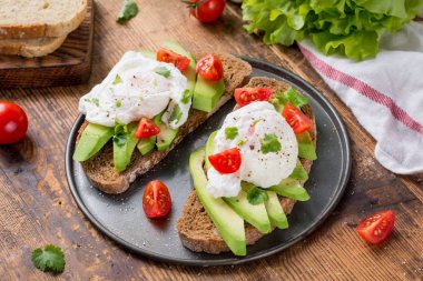 Haşlanmış yumurta, avokado ve tost tam tahıllı ekmek domates