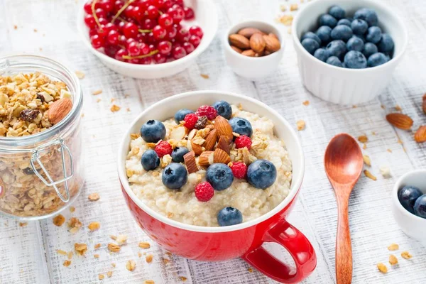 Gachas de avena para un desayuno saludable con bayas frescas y frutos secos —  Fotos de Stock