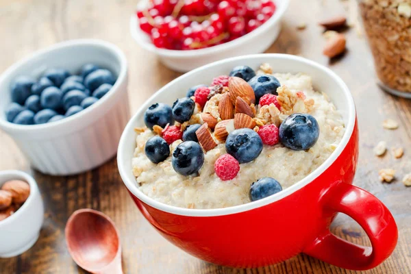 Bol à porridge à l'avoine aux myrtilles, framboises et noix — Photo