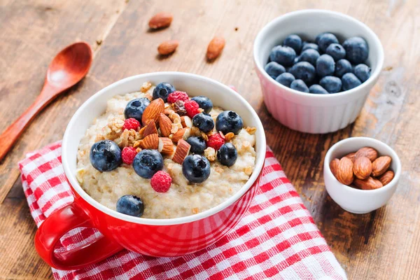 Oatmeal porridge with blueberries, raspberries and muesli — Stock Photo, Image