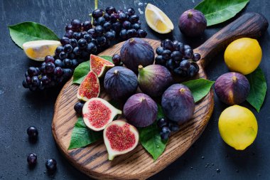 Egzotik meyve tabağı: incir, siyah üzüm ve limon 