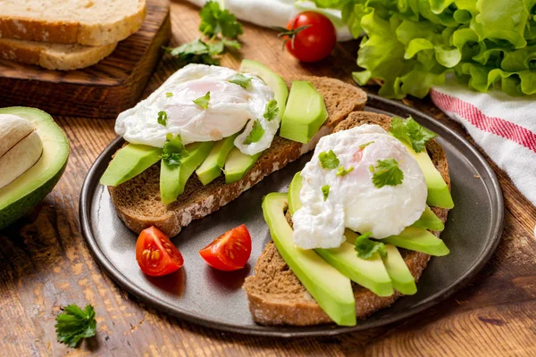 Яйцо-пашот, авокадо и помидоры на тосте для здоровой закуски — стоковое фото