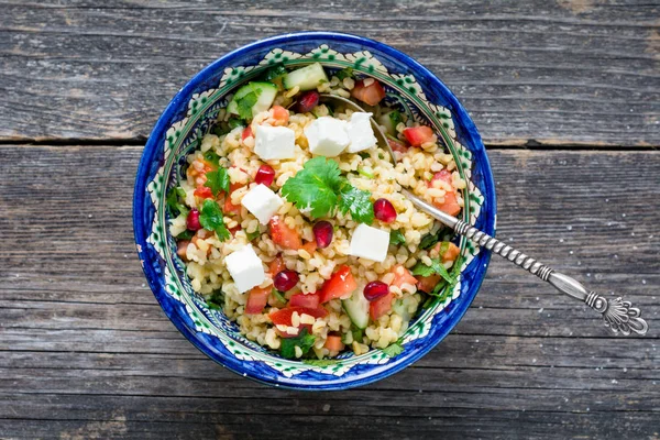 Tabbouleh bulgur, nar taneleri ve taze beyaz peynir salatası