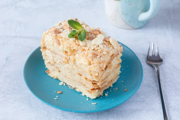 Pezzo di torta Napoleone su piatto blu — Foto Stock