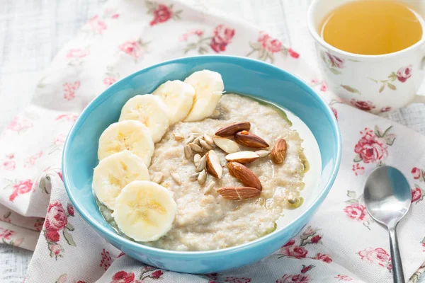 Oatmeal porridge with bananas, nuts, seeds and honey