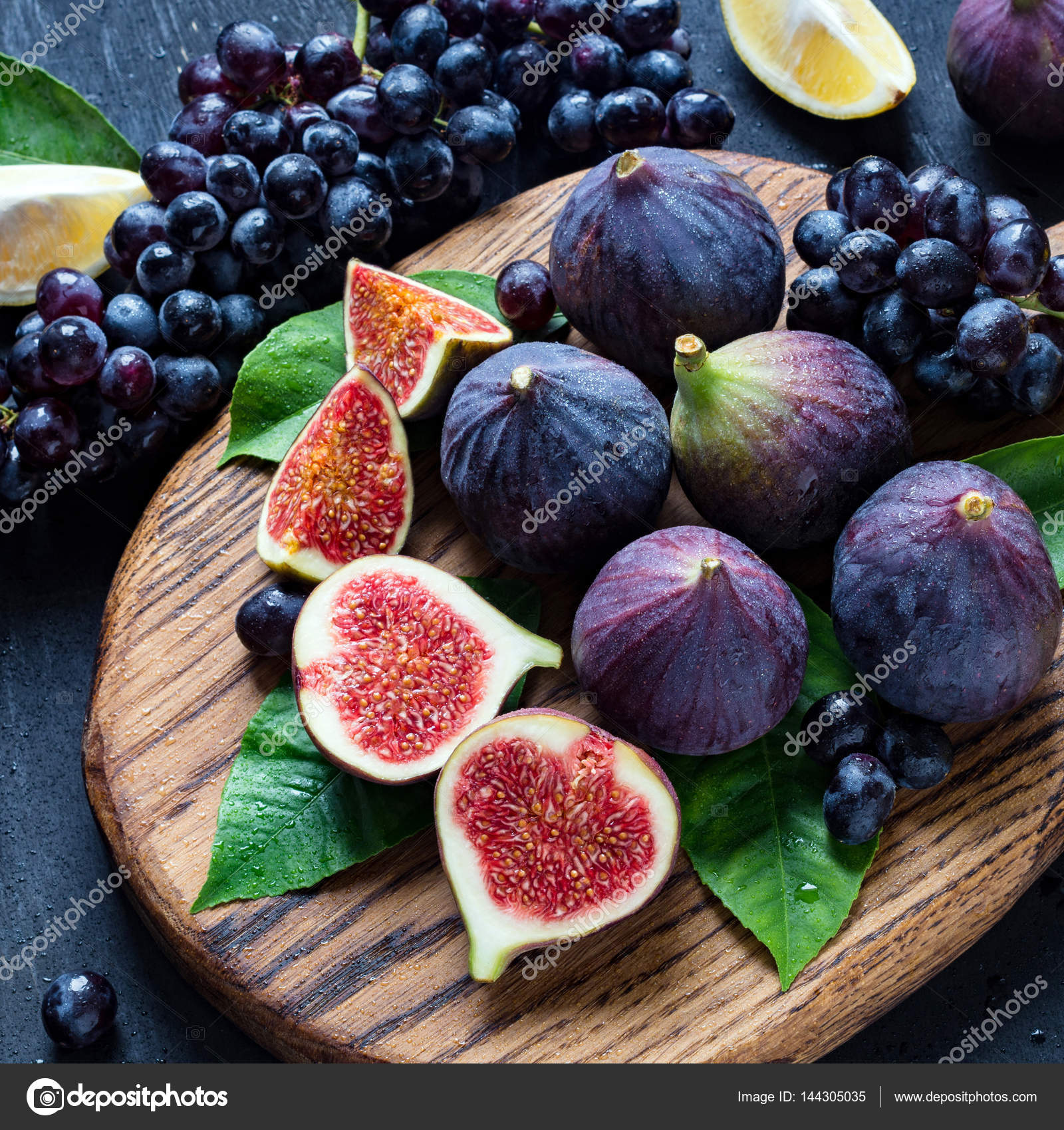 Figs, grapes and lemons fresh fruit plate Stock Photo by