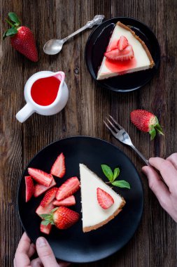 Cheesecake rustik ahşap masa üstü görünümü taze çilek ile
