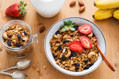 Granola ile kurutulmuş meyveler fındık ve kase çilek 