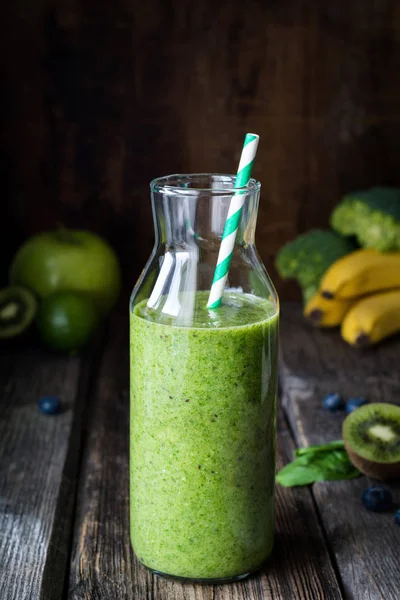 Зеленый смузи в бутылке с соломой — стоковое фото