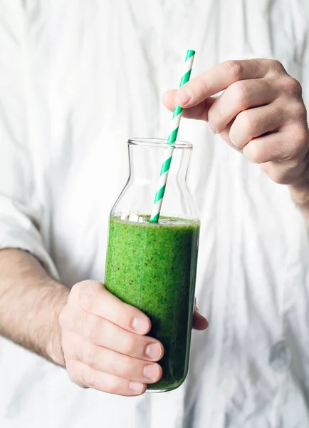 Mains tenant une bouteille de smoothie vert détox — Photo