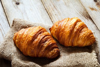 Eski çuval bezi üzerinde taze kruvasanlar