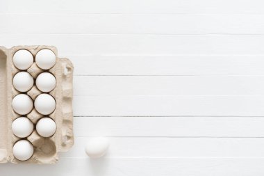 Beyaz ahşap masa kutusunda beyaz yumurta