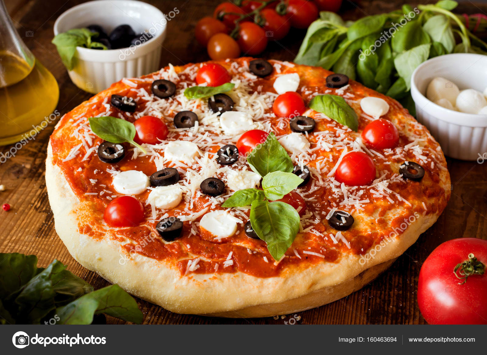 Italian pizza with mozzarella, black olives, tomatoes and basil Stock ...