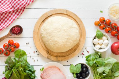 Pizza hamur ve beyaz masaya üst pizza yapmak için malzemeleri görüntüleyin