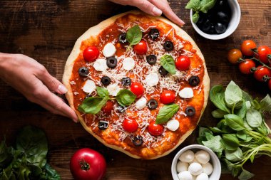 Ev yapımı İtalyan pizza holding eller
