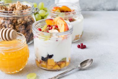 Sağlıklı kahvaltı masası: yoğurt, meyve, bal, müsli ve granola