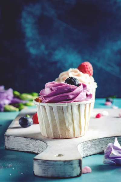 Cupcakes con crema de mantequilla morada y blanca —  Fotos de Stock