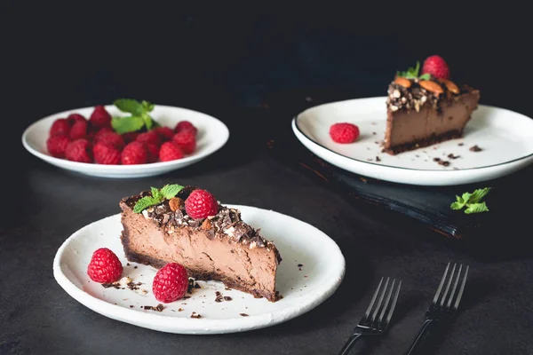 Cheesecake σοκολάτας, διακοσμημένα με σμέουρα και μέντα σε σκούρο φόντο — Φωτογραφία Αρχείου