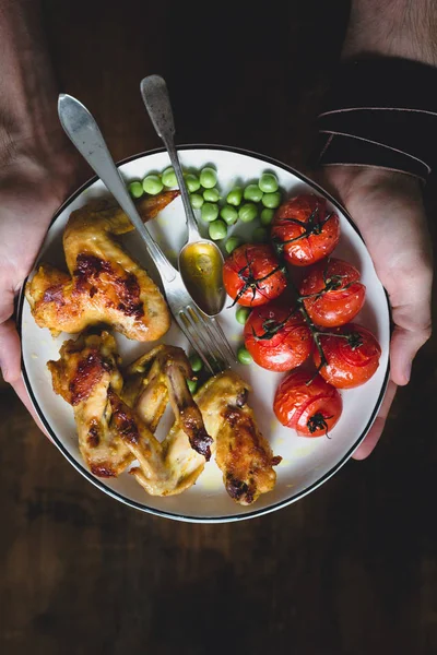 Comida equilibrada en plato con pollo y verduras en las manos del hombre — Foto de Stock